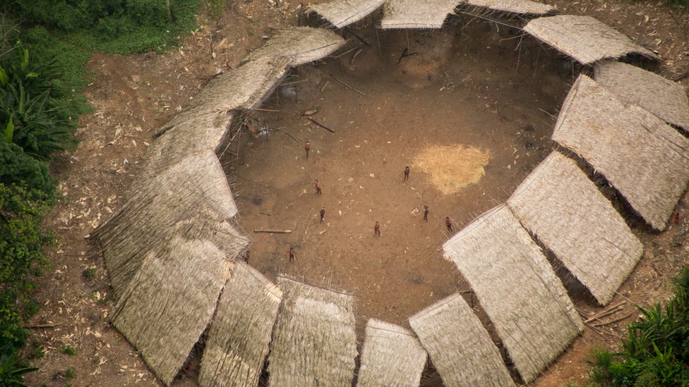 Maloca da comunidade Moxihatëtëma, formada por diveros telhados de palha voltados uns para os outros, com o centro aberto, em maio a clareira na floresta