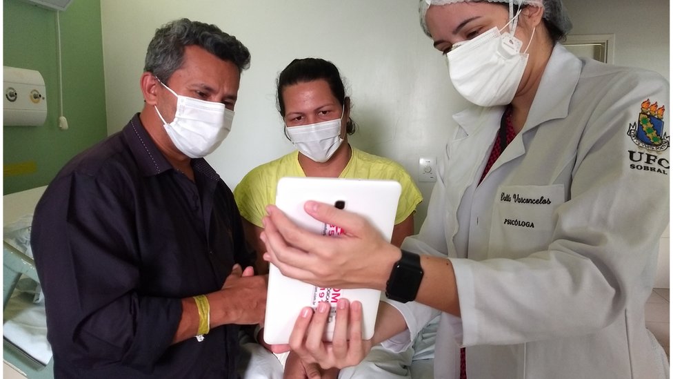 Lurdyani, ao lado do marido, vendo a filha pela primeira vez, por videochamada, 43 dias depois do parto.