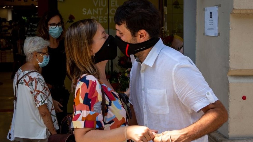 Casal se beija com máscaras