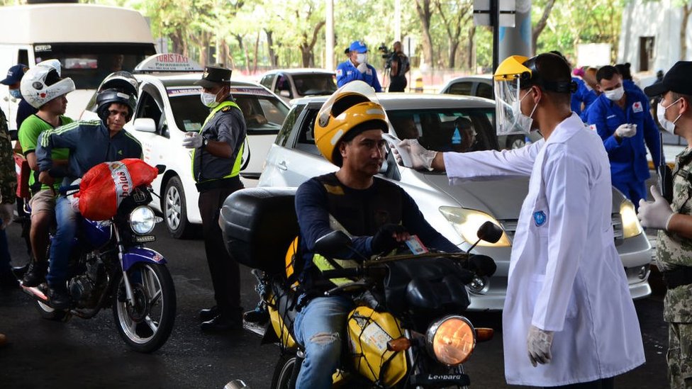 Profissional de saúde mede temperatura de motoqueiro em Curitiba