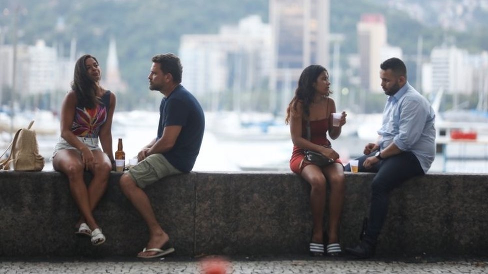 Dois casais conversam em mureta da Urca