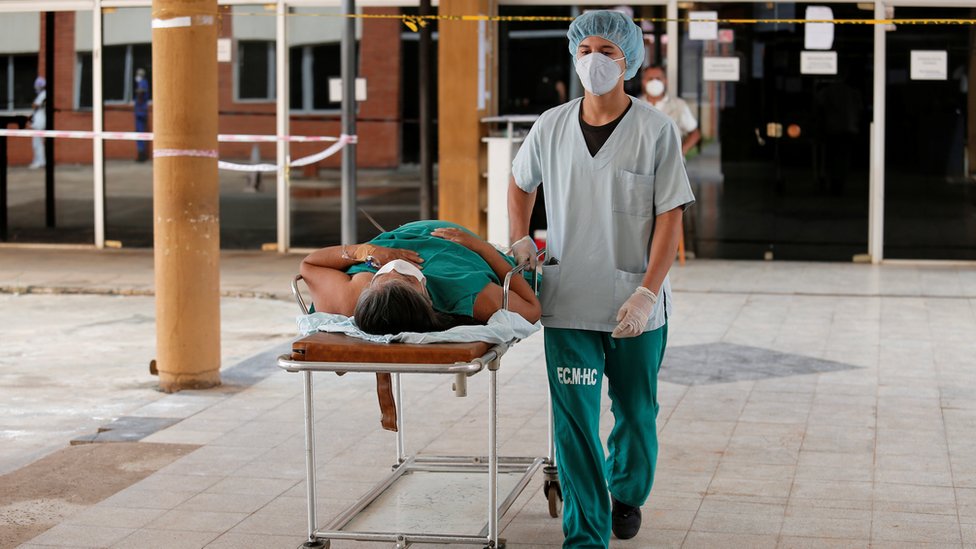 Profissional de saúde leva paciente com covid em maca