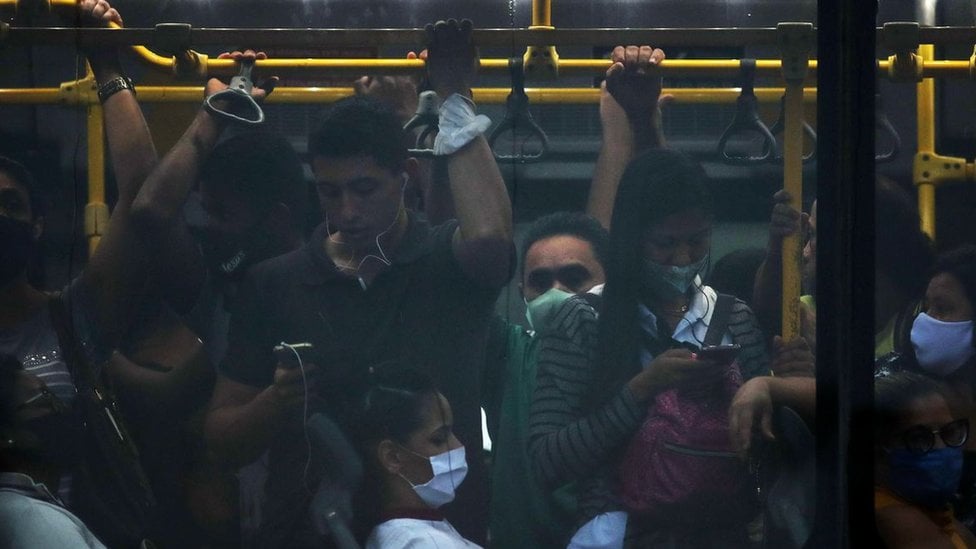 Ônibus lotado com pessoas com e sem máscara na pandemia