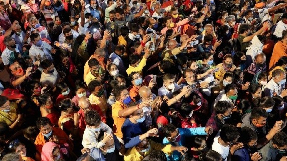 Devotos fazem oração em meio à multidão durante festival