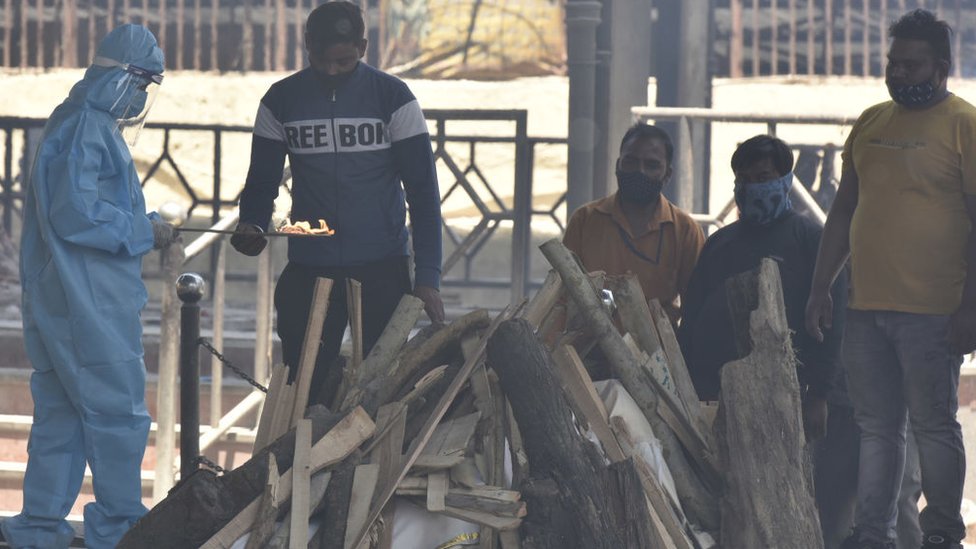 Parentes de uma vítima de covid-19 realizam os últimos ritos durante a cremação no crematório Nigambodh Ghat, em 25 de abril de 2021 em Nova Delhi, Índia