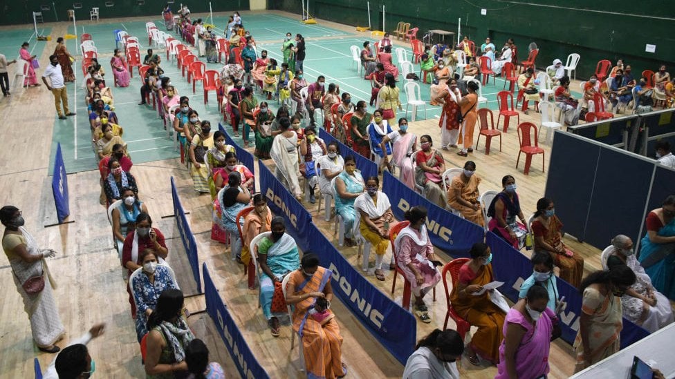 Mulheres na fila para receber a vacina contra o coronavírus em uma campanha de vacinação comunitária em um estádio coberto em Guwahati, Índia.