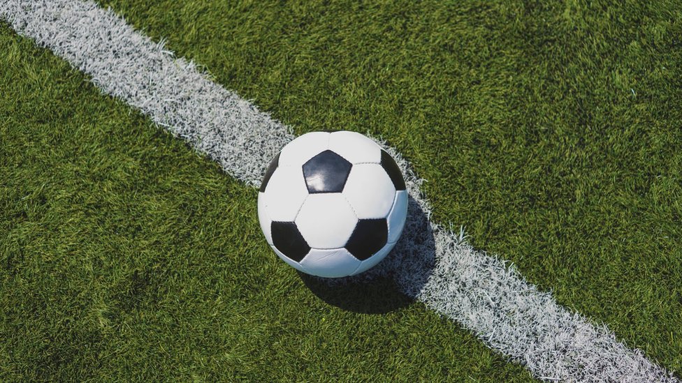 Bola sobre linha em capo de futebol