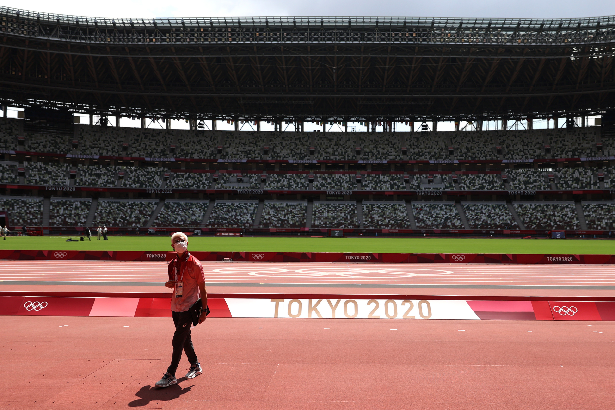 Pessoa com máscara em estádio vazio