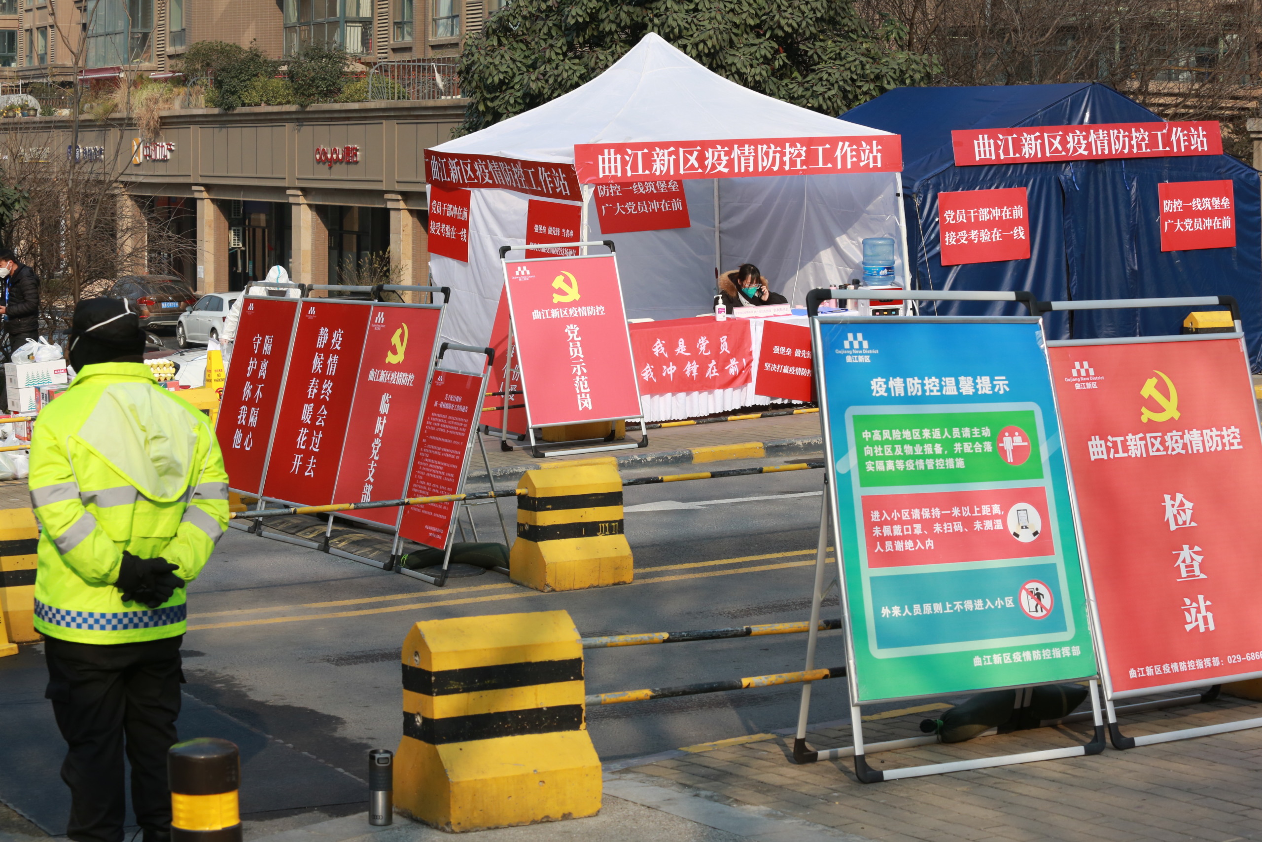 Funcionários do governo guardam em um posto do lado de fora de um bloco residencial em Xi'an