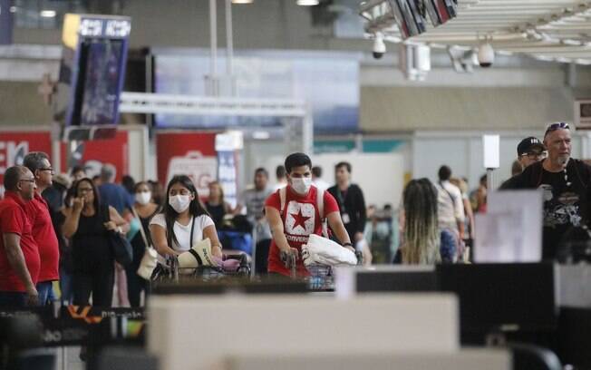 Pessoas em um aeroporto utilizando máscaras