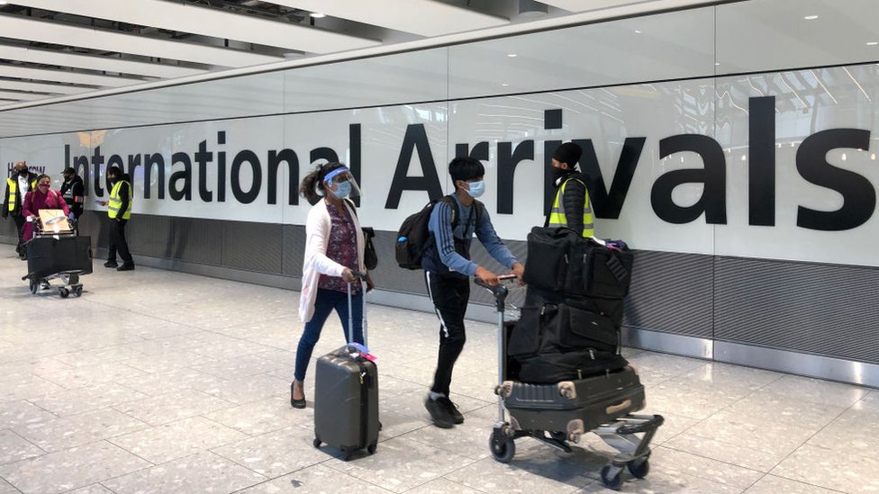 Pessoas com malas no terminal de chegadas do aeroporto de Heathrow
