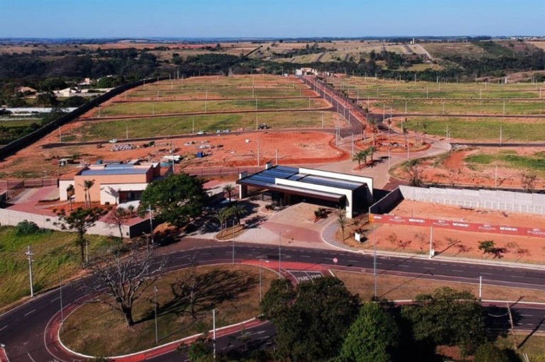 Vista aérea do Residencial Boulevard Park Resort, com salão de festas ao lado da entrada e clube social ao fundo, voltado para o vale