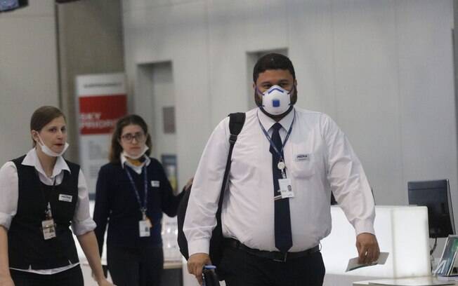 Funcionários de um aeroporto utilizando máscaras para se proteger contra o novo coronavírus