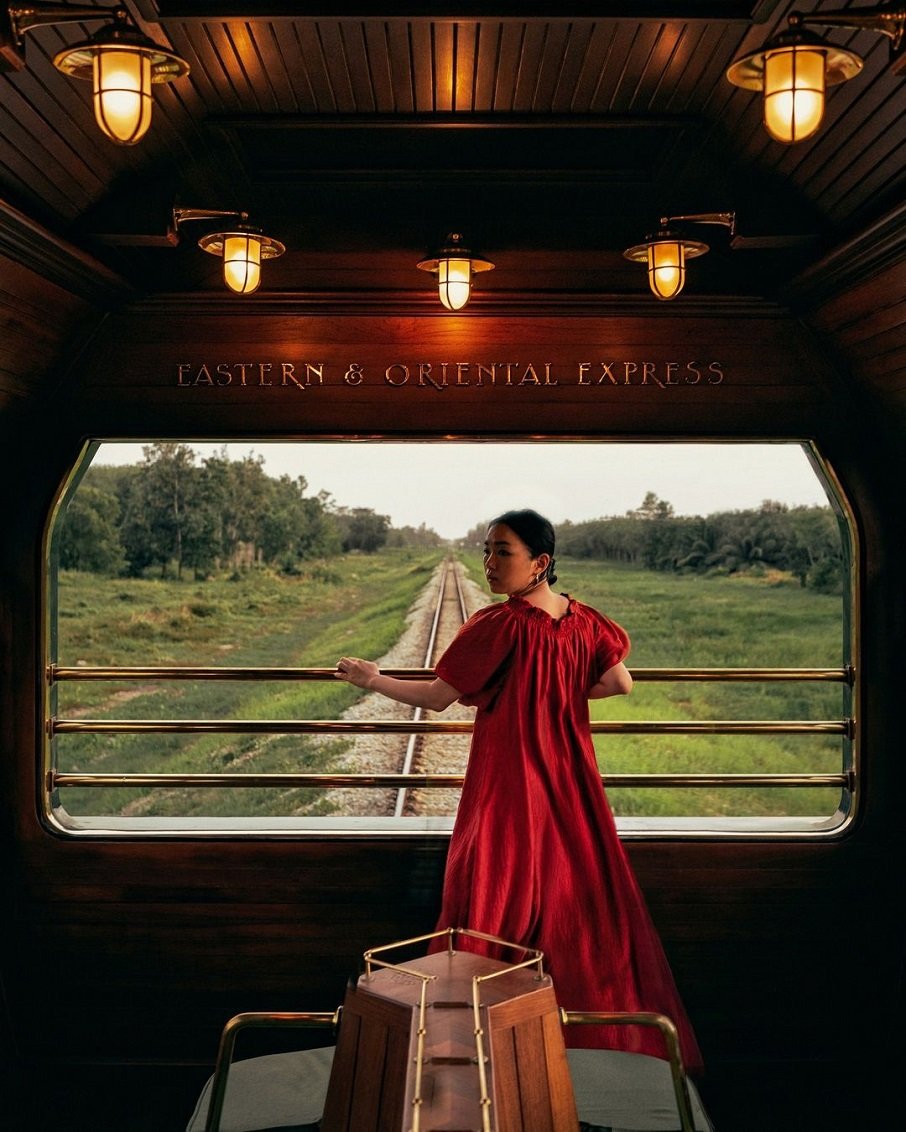 Passageira posa no trem de luxo The Eastern & Oriental Express, da Belmond, que faz itinerário no Sudeste Asiático