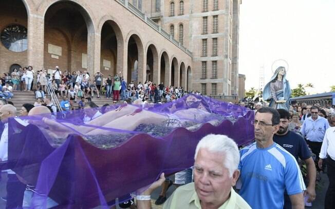 Devotos carregando uma representação de Jesus Cristo em um caixão aberto