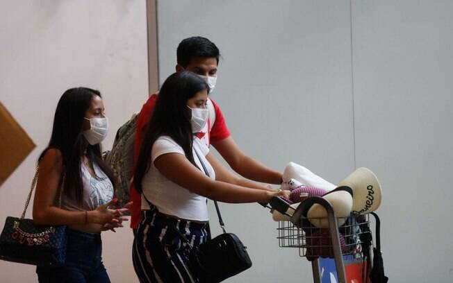 Pessoas no aeroporto usando máscaras