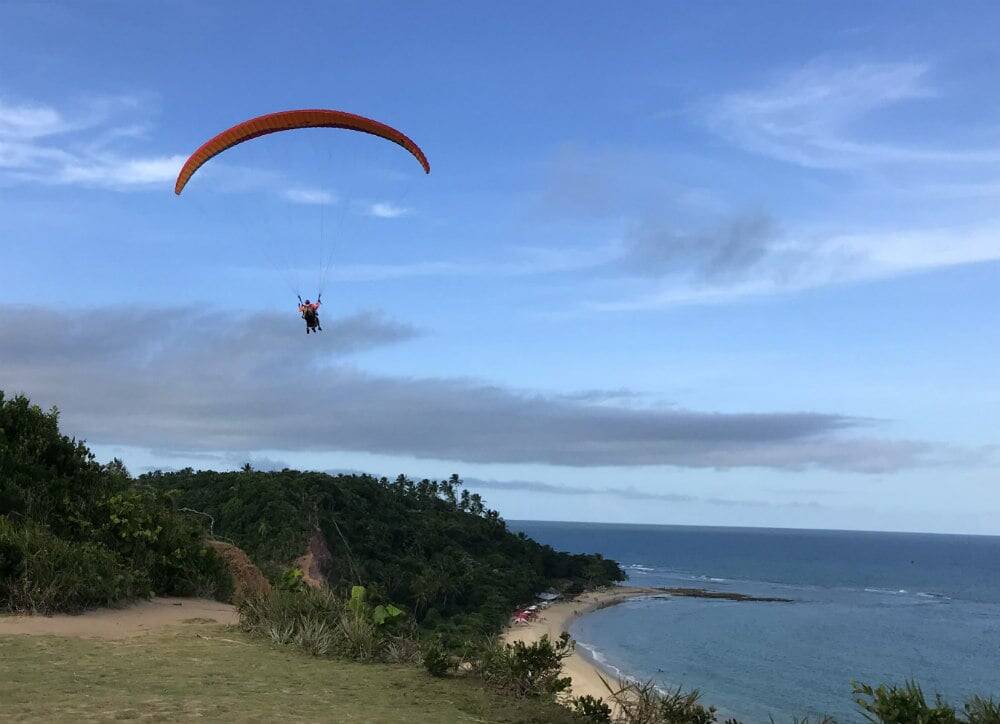 Voos de parapente são passeios recorrentes em Arraial d'Ajuda. Foto: Guia Mundo Afora