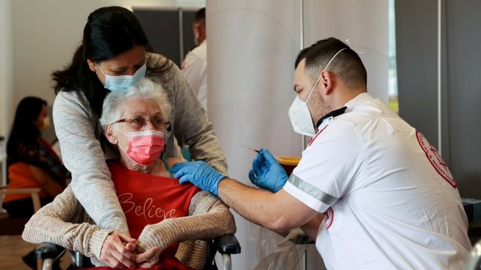 Uma senhora recebe doses em Netanya, Israel