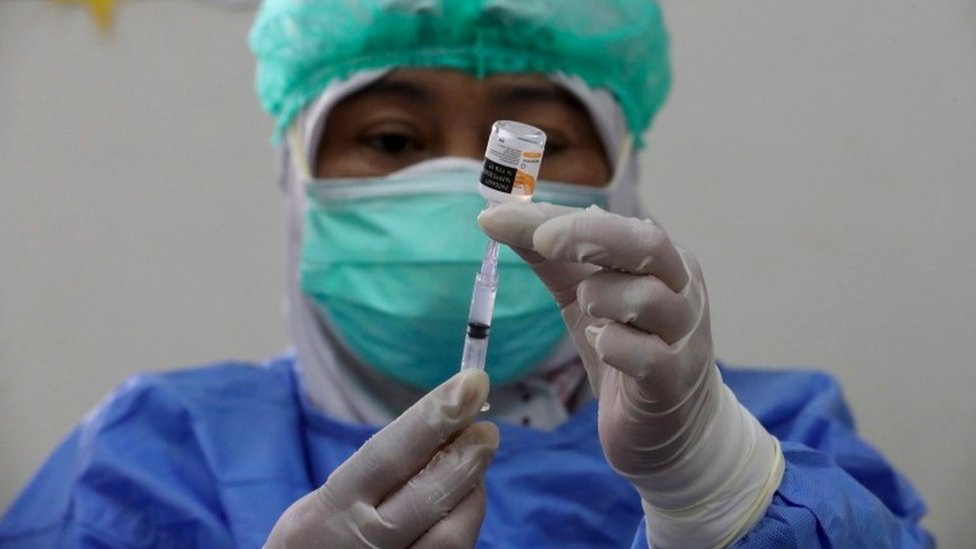 Uma profissional de saúde prepara uma dose de vacina