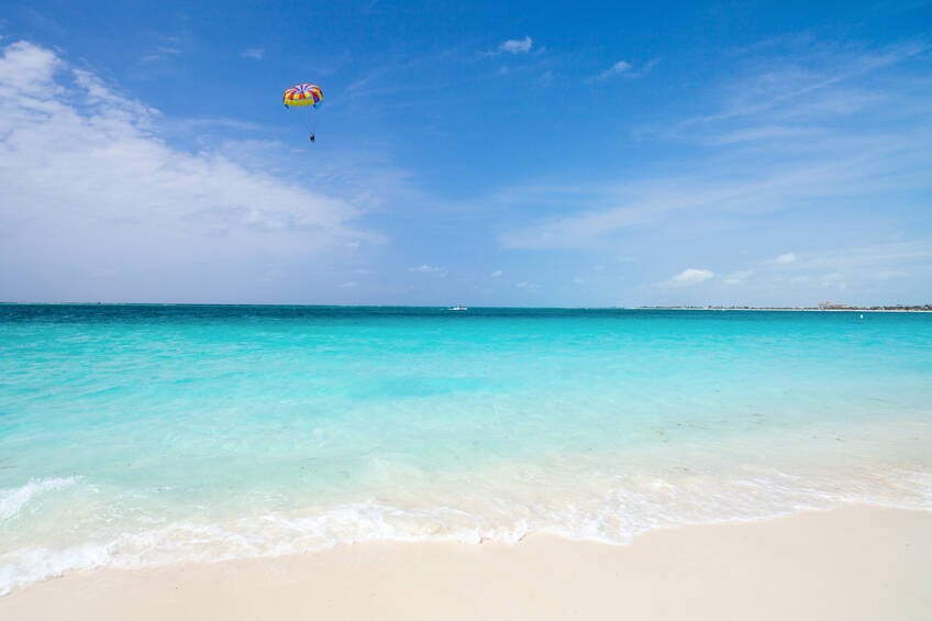 Parasailing está entre as atividades possíveis em Grace Bay Beach. Foto: Qual Viagem