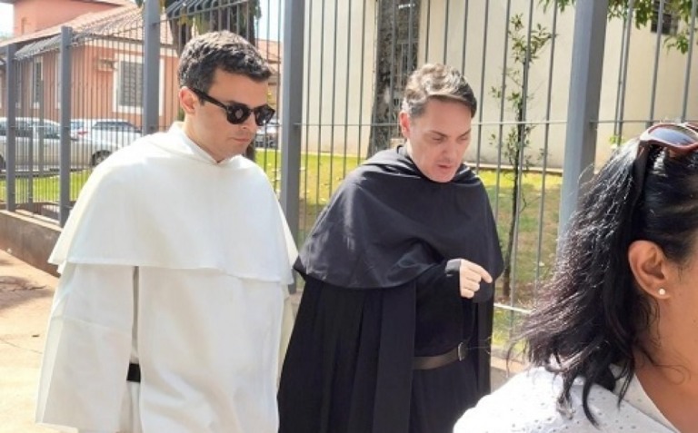 Padre Gustavo, de batina branca, em frente ao F´roum – IBTV News