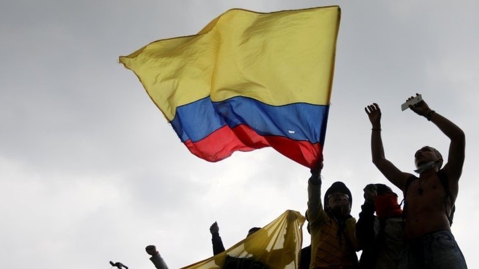 Manifestantes com bandeira colombiana