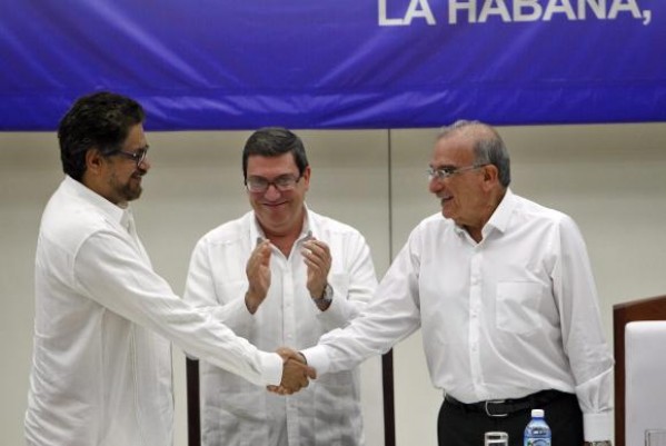 Luciano Marín, das farcs, e o ex-vice-presidente da Colômbia, Humberto de la Calle, apertam as mãos após acordo histórico em Havana – EPA/Lusa