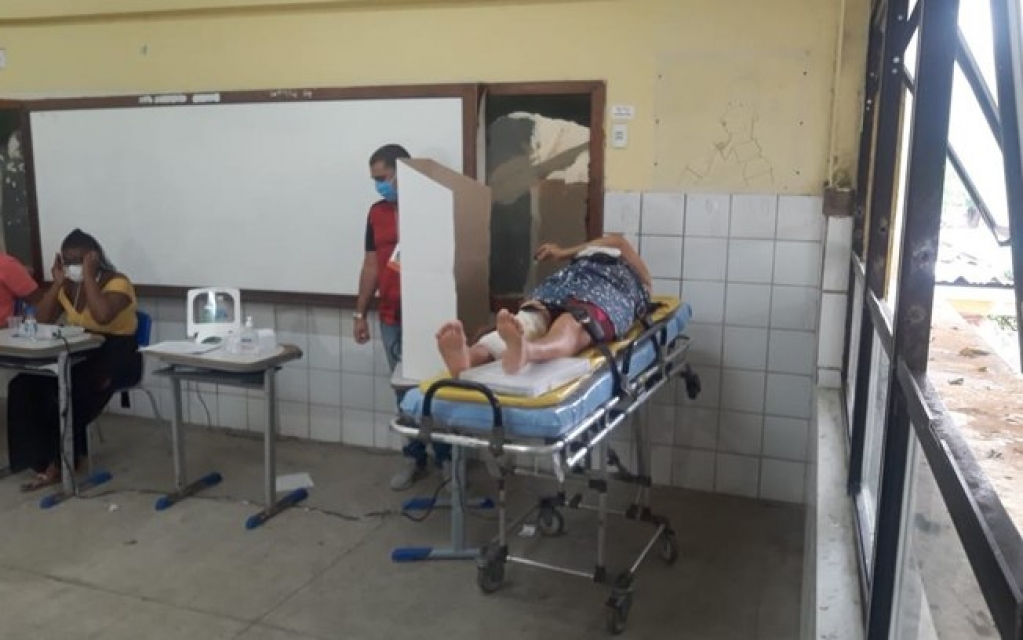 Eleitora leva queda em colégio eleitoral e vota carregada em maca