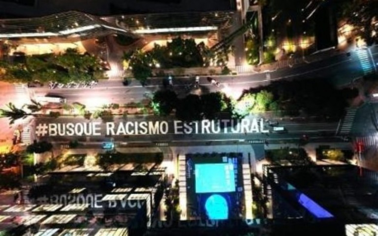 Artistas ativistas pintam "Busquem Racismo Estrutural" na Avenida Faria Lima