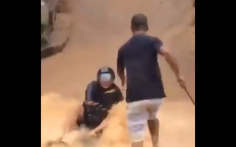 Passageiro cai de moto e é arrastado por enxurrada em favela no Rio; assista