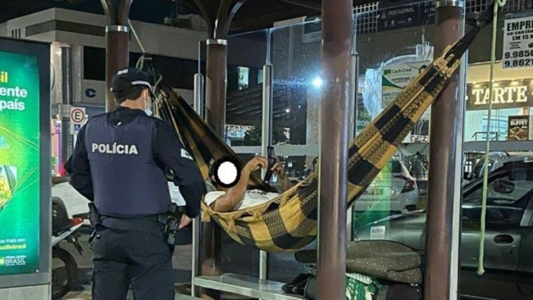 Homem foragido é encontrado deitado em uma rede pendurada no ponto de ônibus