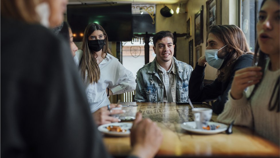 Grupo de jovens sentados ao redor de uma mesa