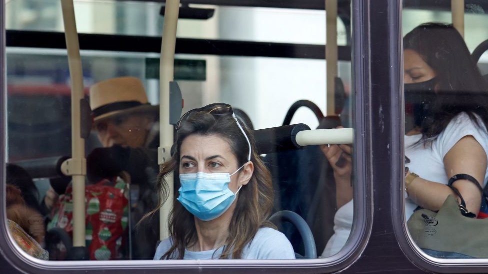 Mulher olha pela janela de um ônibus em Londres