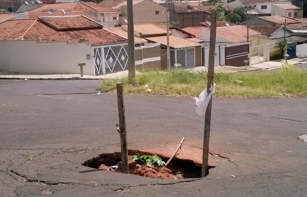 Moradores sinalizam buracos para conter riscos