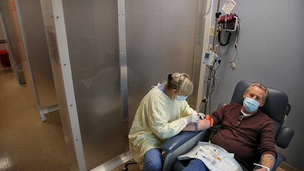 Profissional da saúde aplica anticorpo monoclonal na veia de paciente